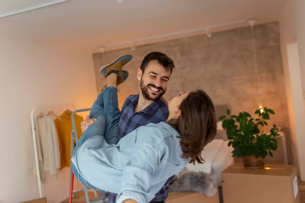 Husband carrying his wife in their living room