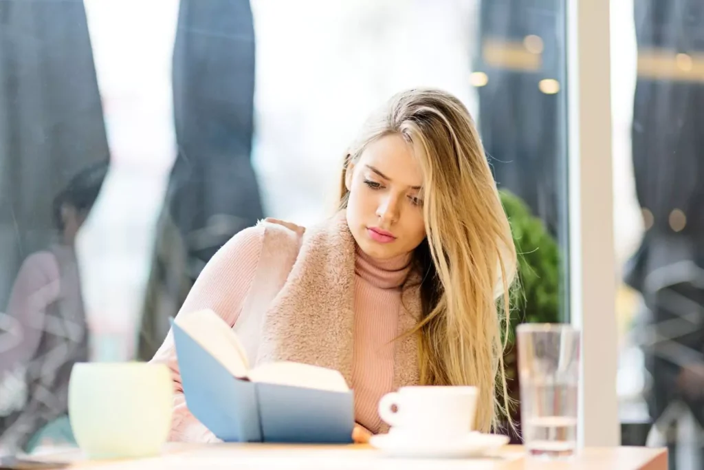 a single woman reading and drinking coffee