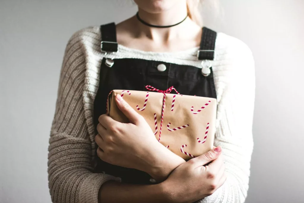 a woman holding a Christmas present, part of her Christmas tool kit