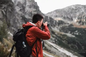 a man taking a photo of a mountain - an artist