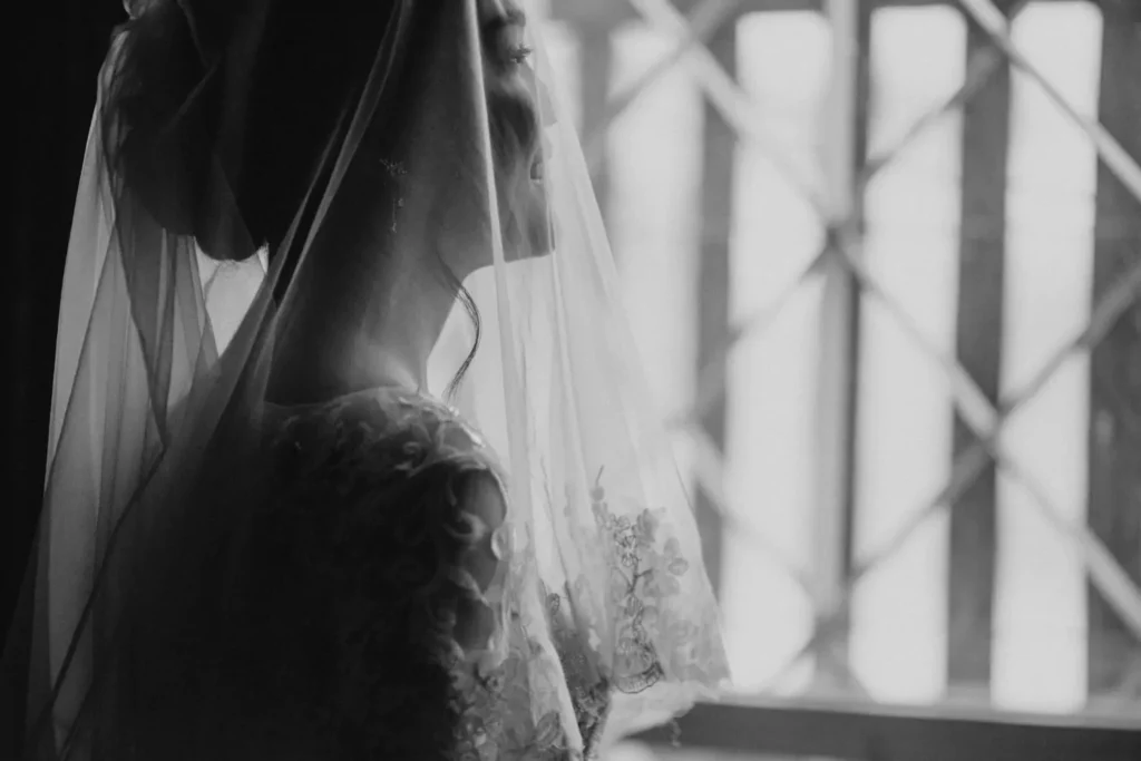 a bride, preparing to get married, looking out a window