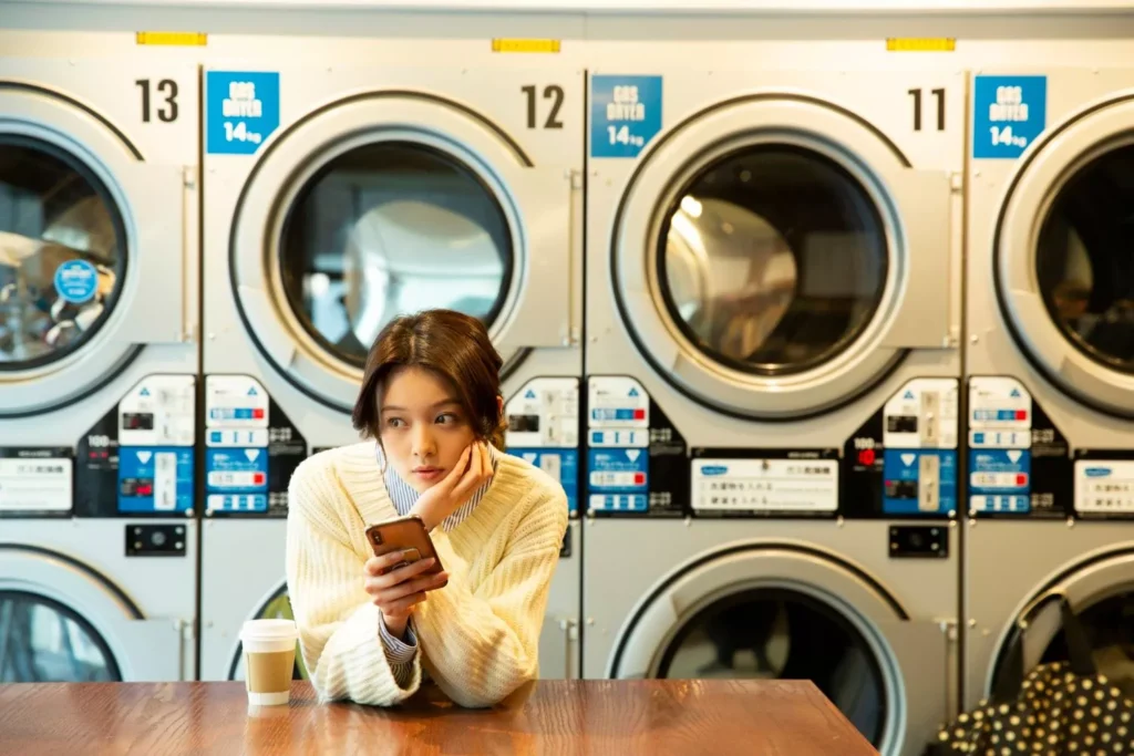 a woman waiting at the laundromat for her clothes to be done