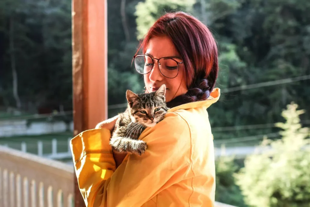 a woman holding a cat representing the cat lady stereotype