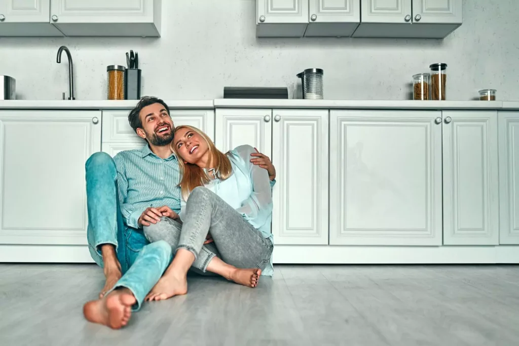 a married couple sitting on the kitchen floor, making bids for connection