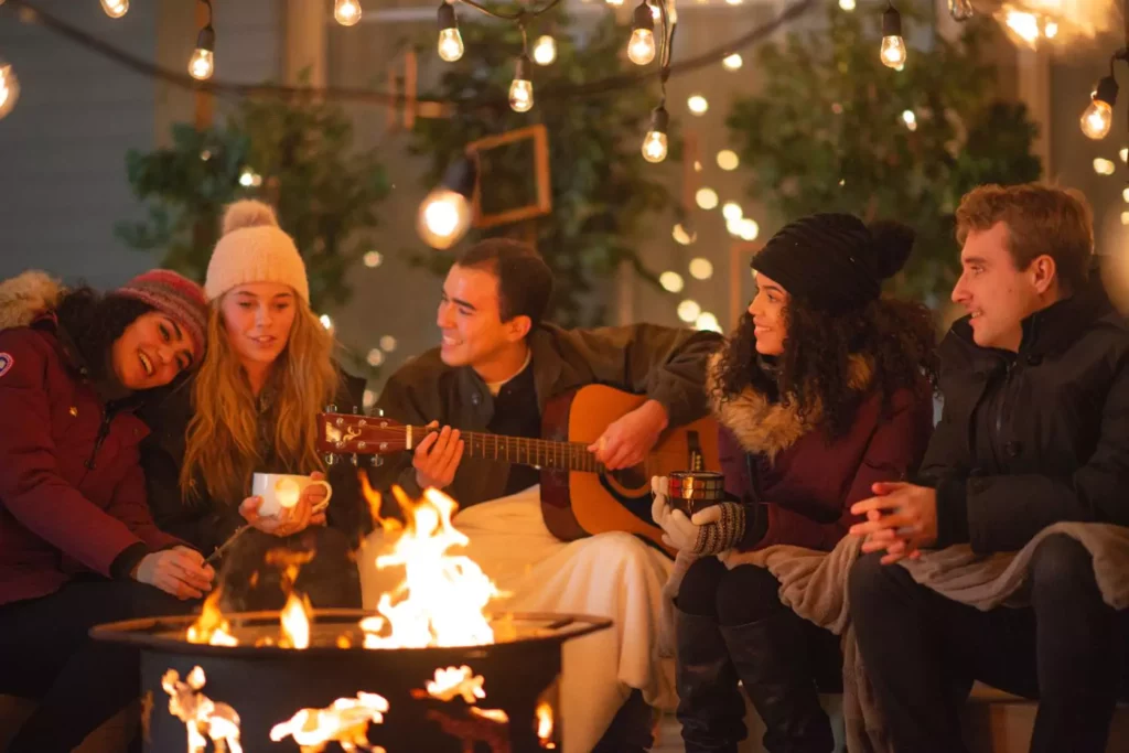 Friends sitting around a fire. Hygge