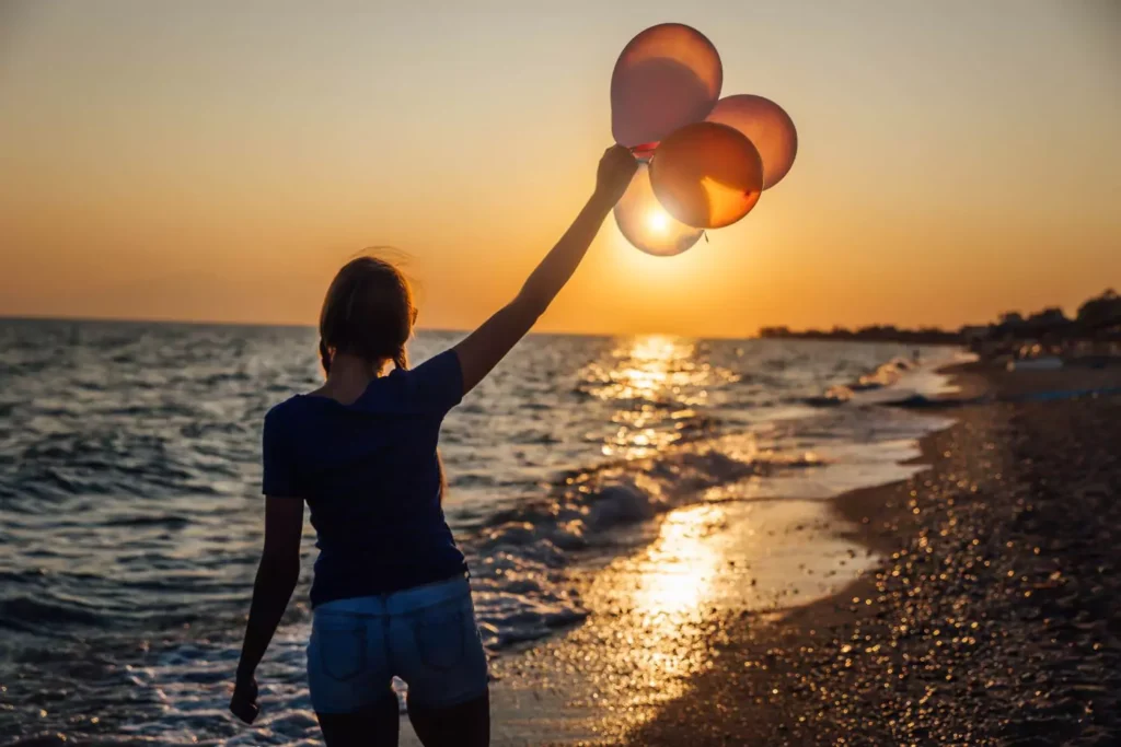a woman holding balloons and following her dreams