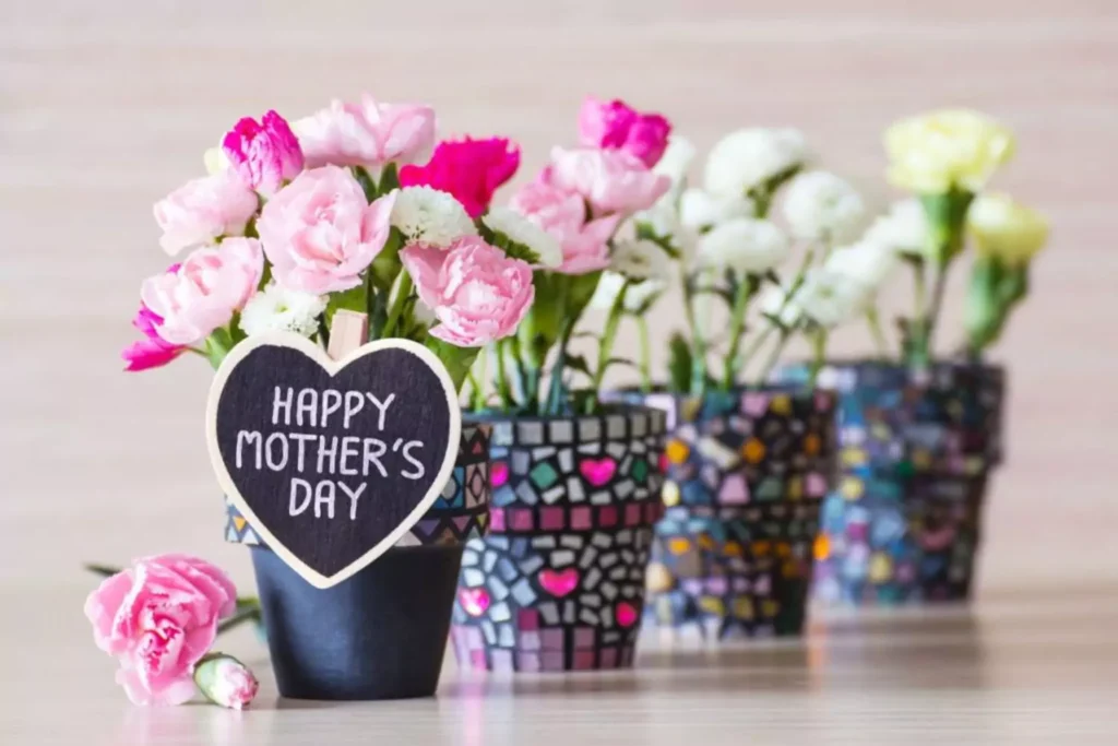Flowers in pots with a sign that says Happy Mother's Day