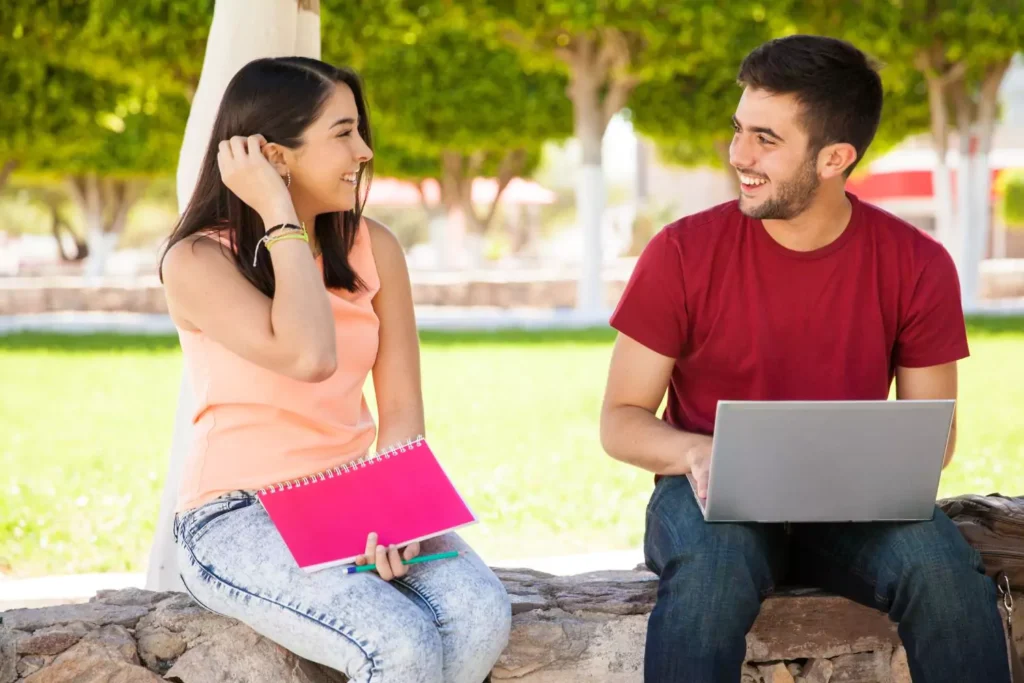 a woman and man sitting on a bench, one leading the other on