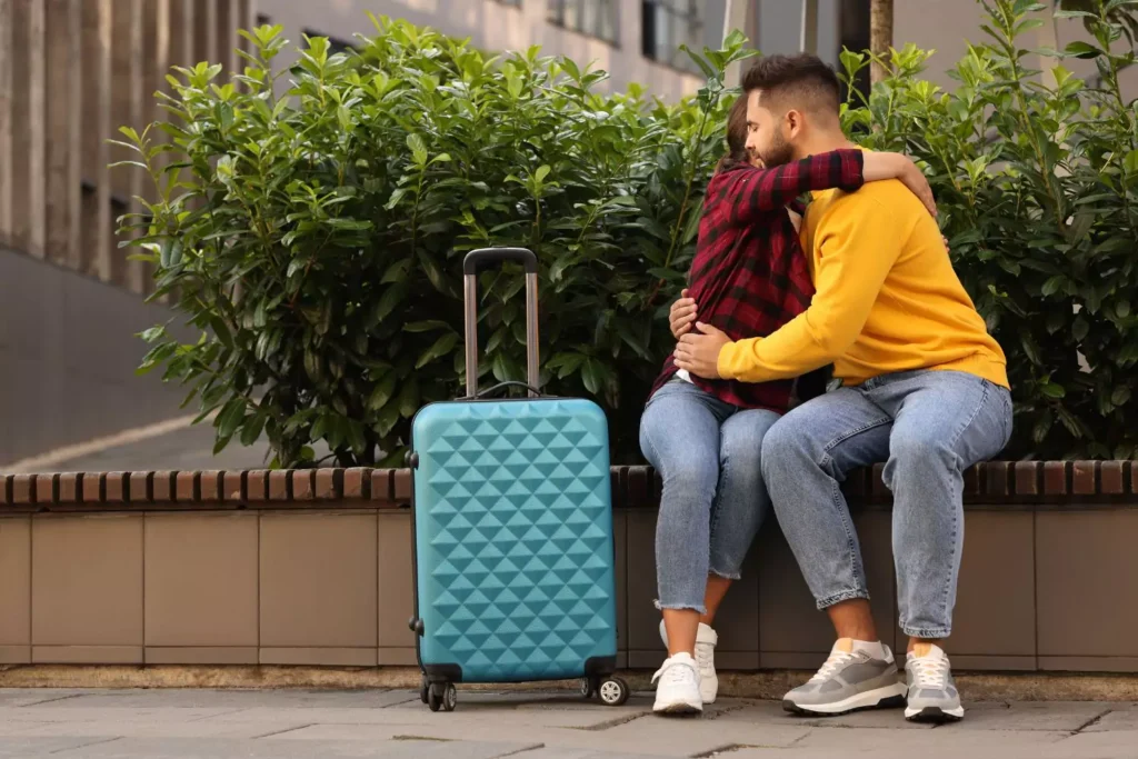 a long-distance dating couple, hugging at the airport