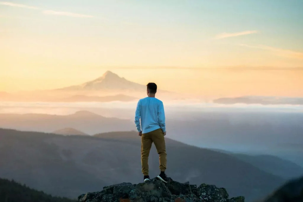 a man standing on a mountain top, making the most of his unemployment