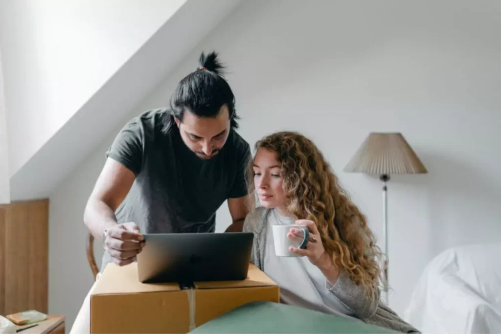 a couple merging schedules on their laptop