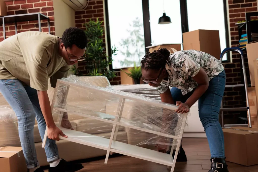 a husband and wife moving furniture, open to what the Lord has for them