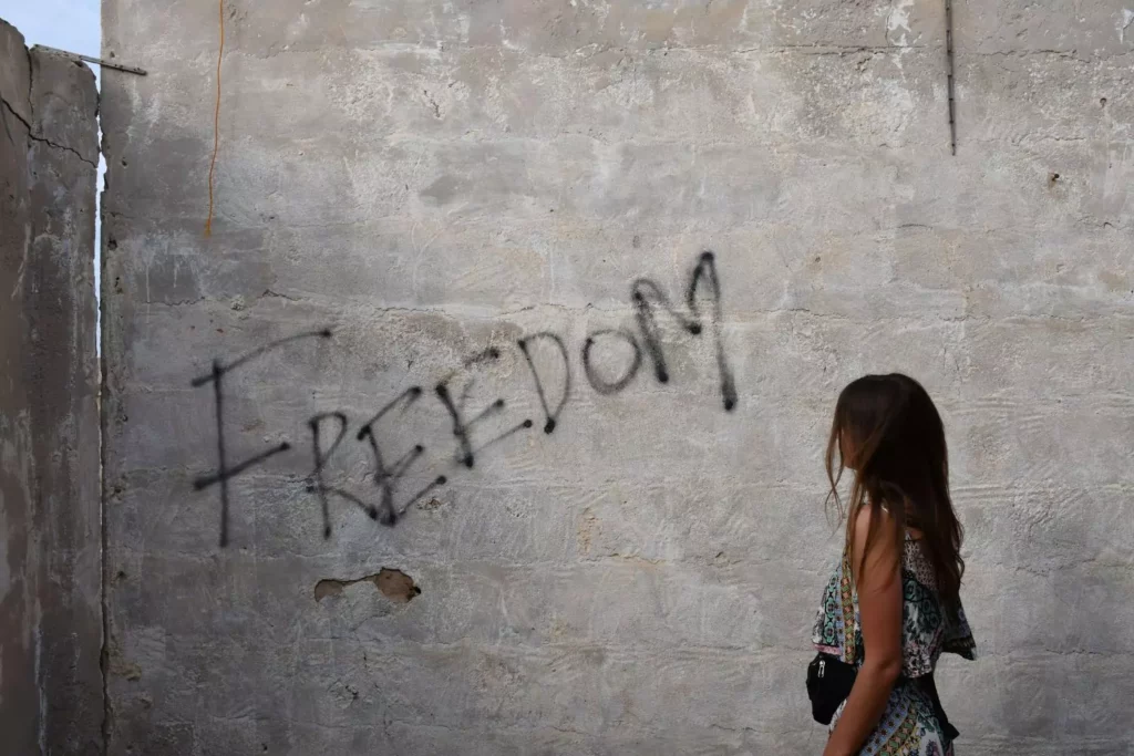 a woman finds hope that she can overcome a struggle with pornography, she's looking at graffiti that says "freedom"