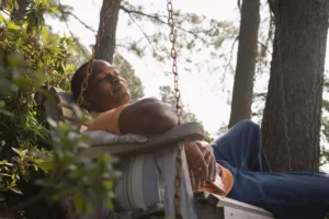 a man resting on a porch swing