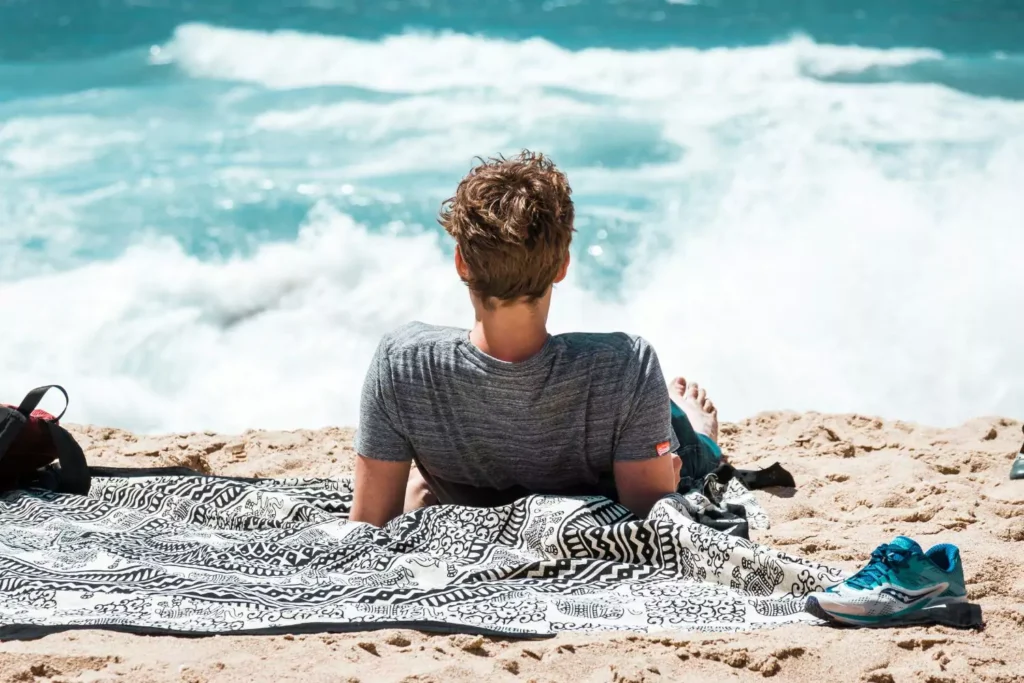 a man doing self-care by relaxing on a beach