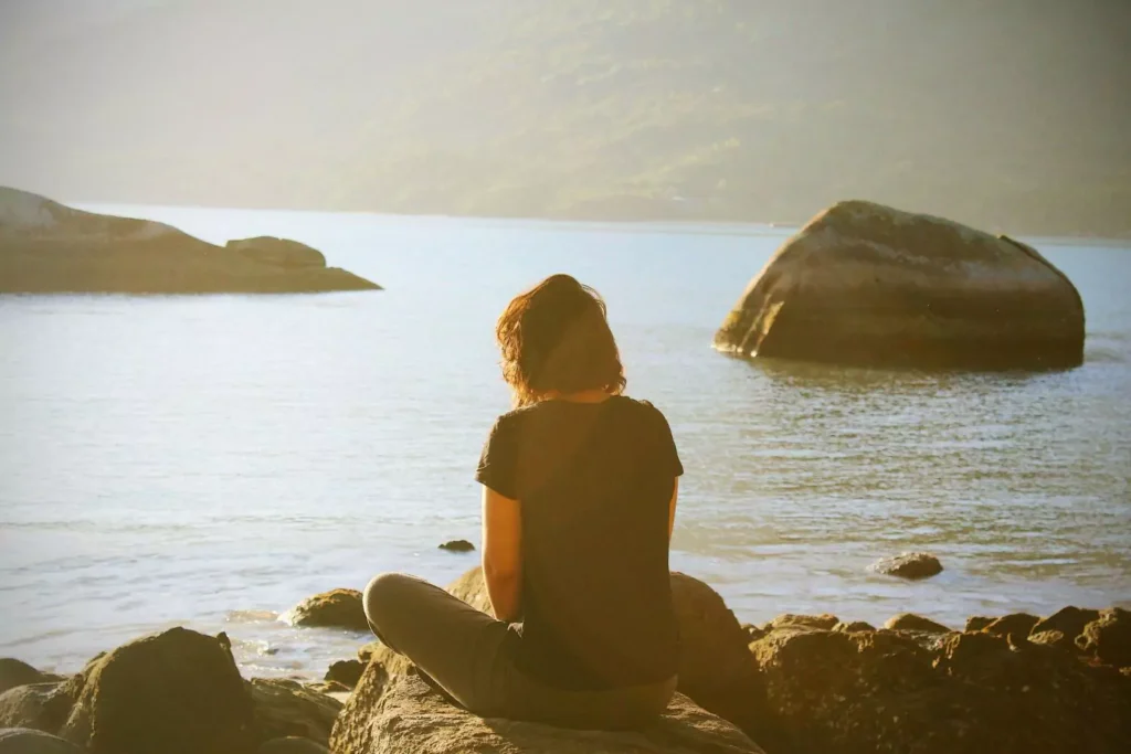 a woman practicing mindfulness by a lake
