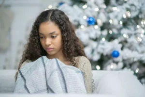 woman looking sad in front of a Christmas tree, lonely