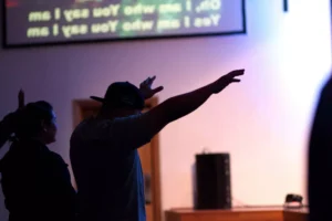 a man raising his hands in praise at a church service
